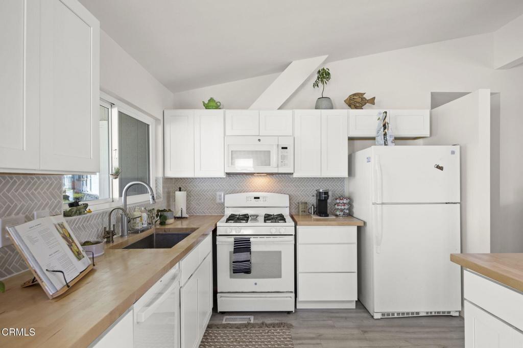 400 Dewberry Lane, Unit 101 Oxnard, CA 93036 - Photo 10 of 37 a kitchen with a white stove top oven and refrigerator