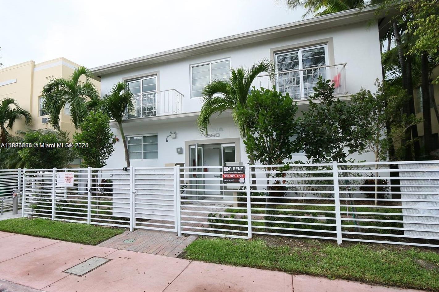 a view of a house with a yard plants and large tree
