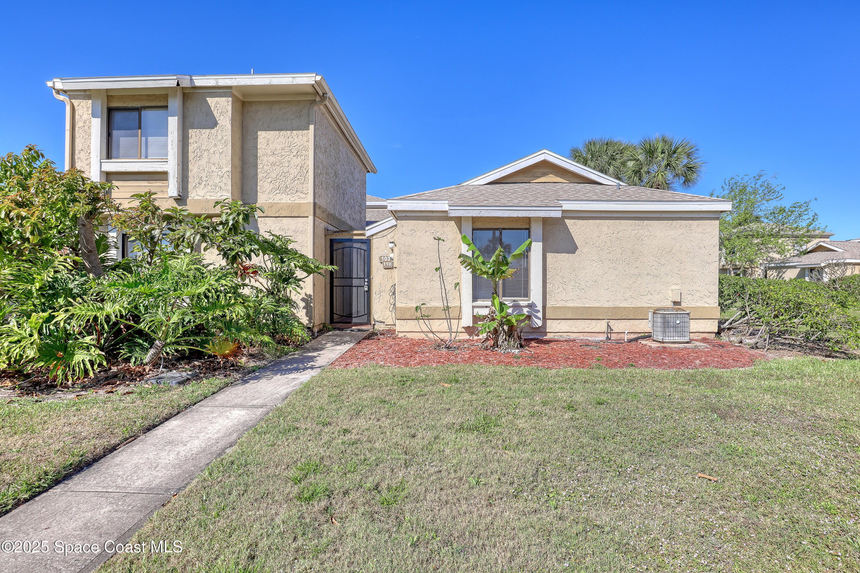 1031 Abada Court Northeast, Unit 110 Palm Bay, FL 32905 - Photo 1 of 33 a front view of a house with a yard and garage