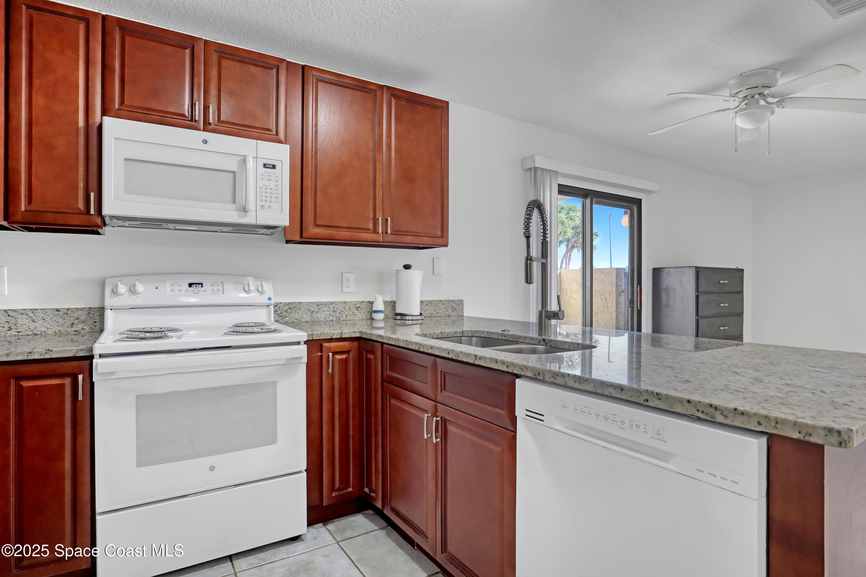 1031 Abada Court Northeast, Unit 110 Palm Bay, FL 32905 - Photo 16 of 33 a kitchen with granite countertop cabinets stainless steel appliances and a sink