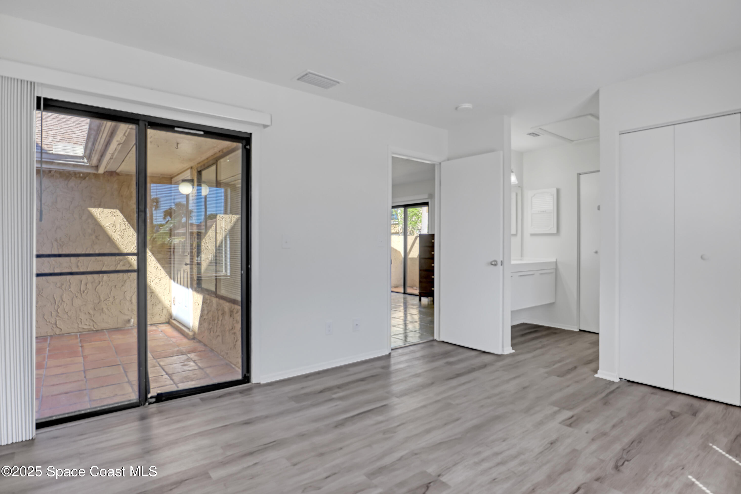 1031 Abada Court Northeast, Unit 110 Palm Bay, FL 32905 - Photo 19 of 33 a view of empty room with wooden floor and fan