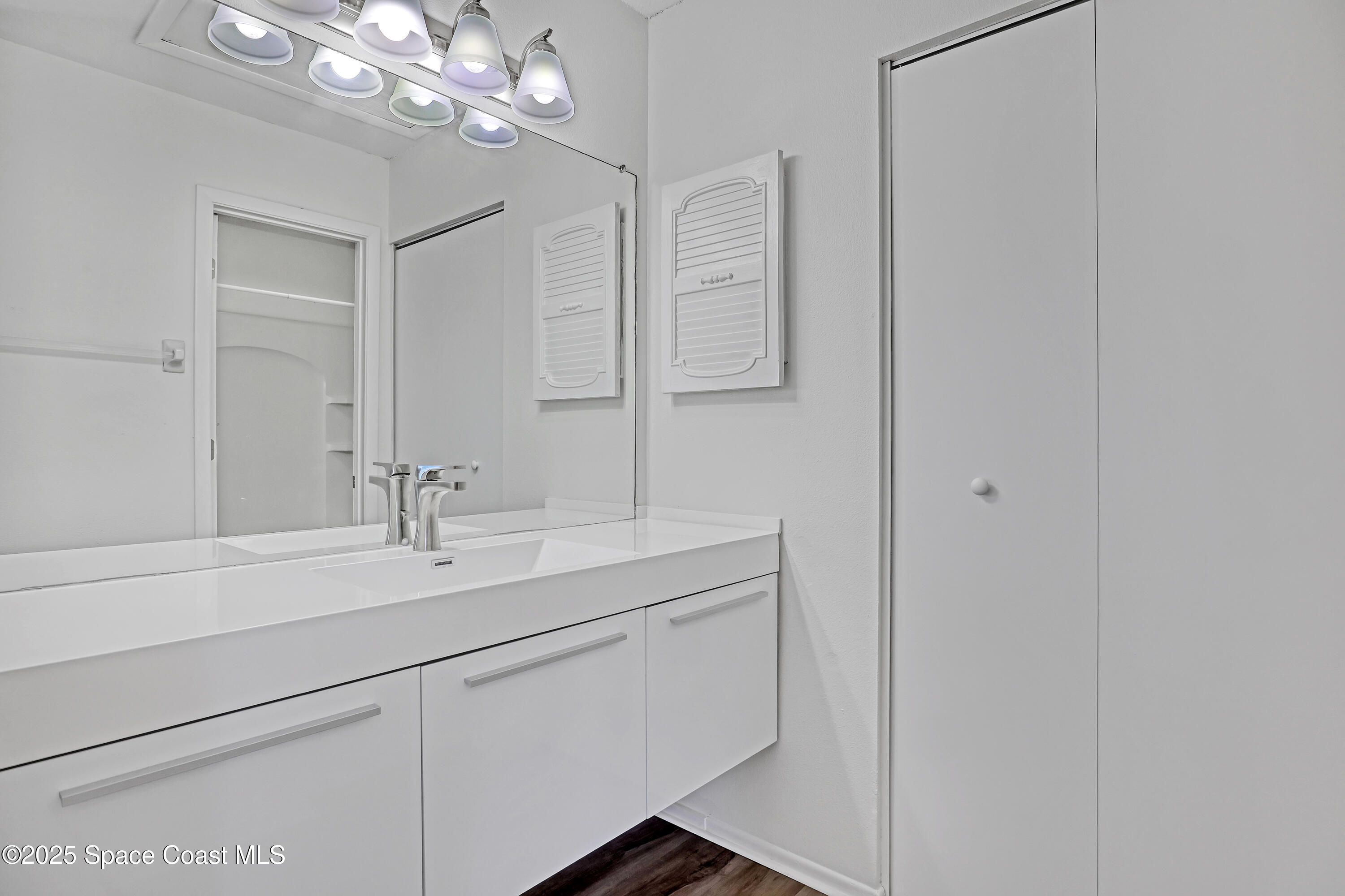 1031 Abada Court Northeast, Unit 110 Palm Bay, FL 32905 - Photo 21 of 33 a bathroom with a sink a light fixture and a mirror