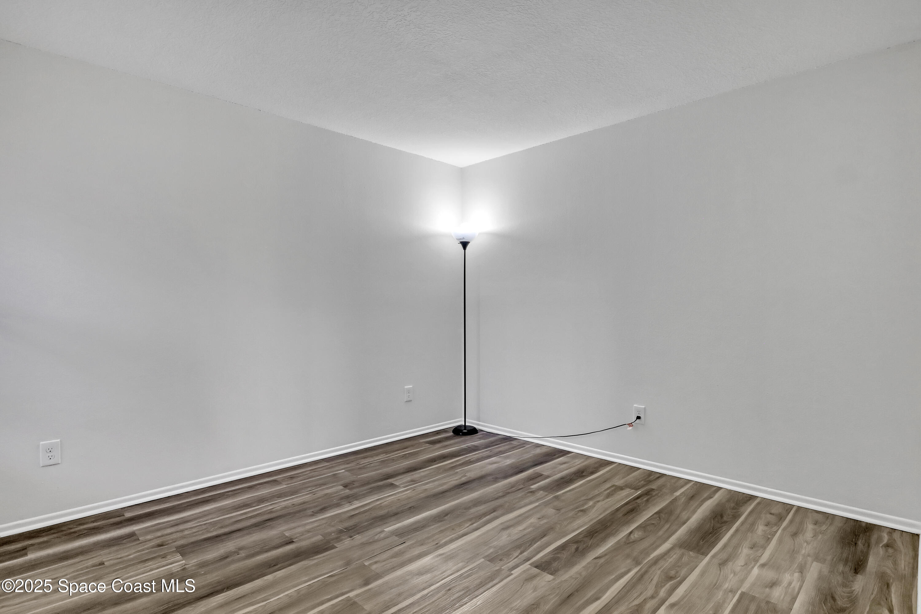 1031 Abada Court Northeast, Unit 110 Palm Bay, FL 32905 - Photo 23 of 33 a view of a room with wooden floor and fan