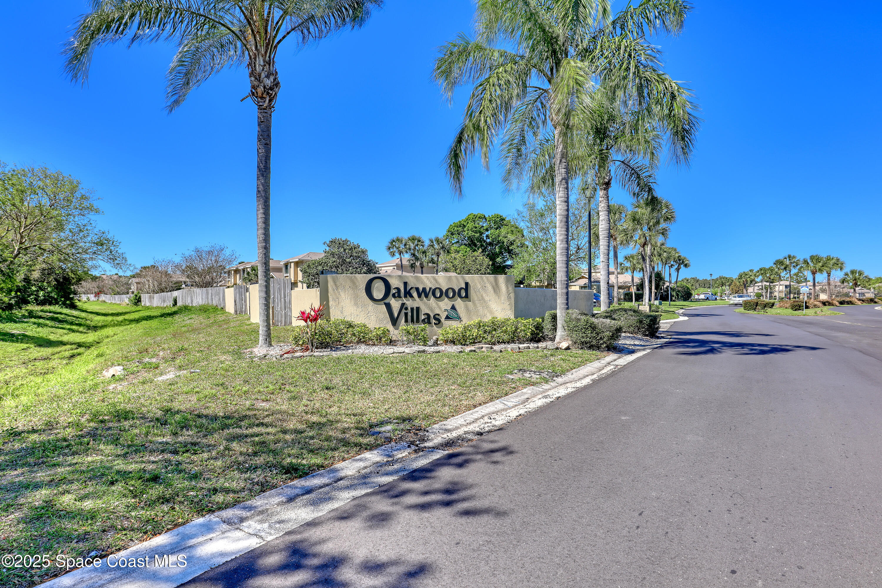 1031 Abada Court Northeast, Unit 110 Palm Bay, FL 32905 - Photo 27 of 33 a sign board with a yard and palm trees