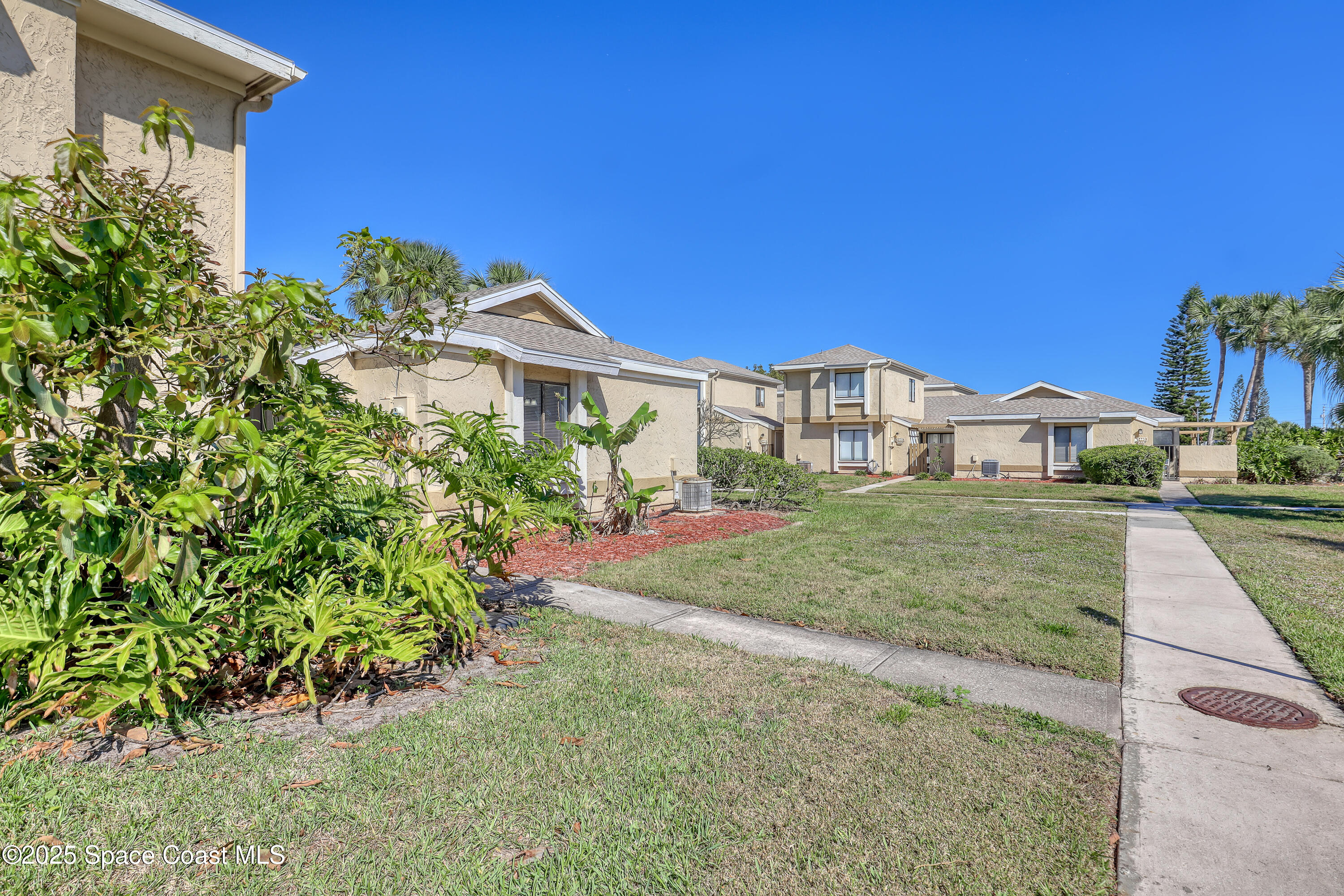 1031 Abada Court Northeast, Unit 110 Palm Bay, FL 32905 - Photo 3 of 33 a view of a house with a yard and garden