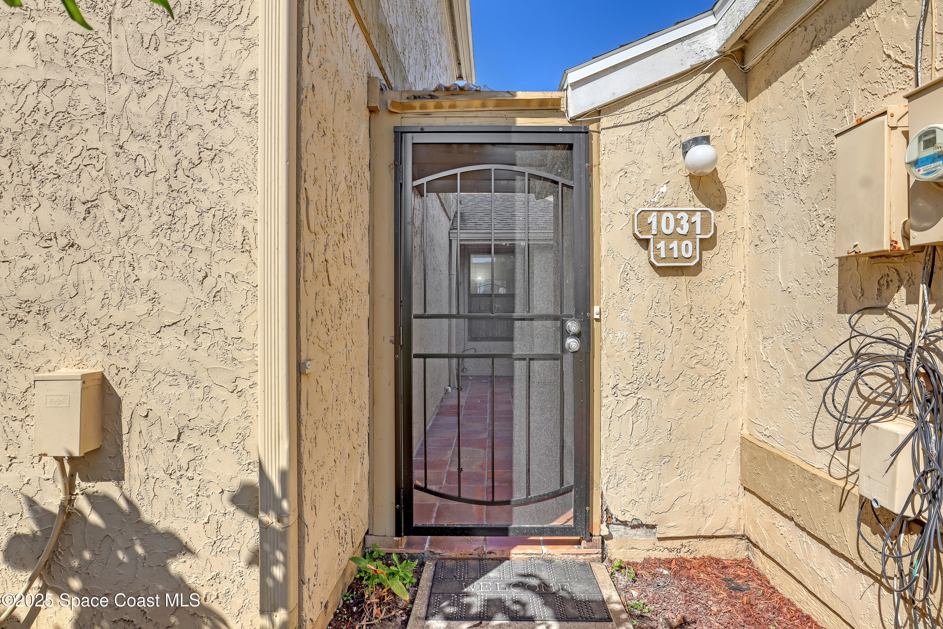 1031 Abada Court Northeast, Unit 110 Palm Bay, FL 32905 - Photo 4 of 33 a view of a door and chair in the house