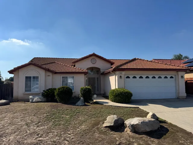 a view of a house with a yard and potted plants