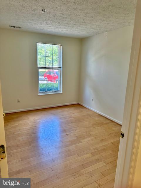 696 Winding Stream Way, Unit 104 Odenton, MD 21113 - Photo 14 of 21 an empty room with wooden floor and windows