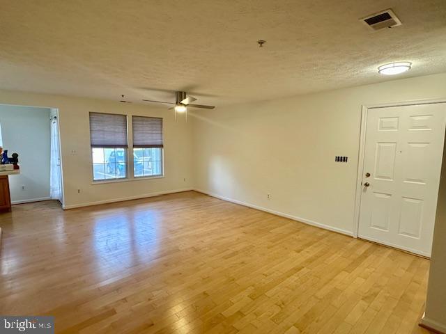 696 Winding Stream Way, Unit 104 Odenton, MD 21113 - Photo 6 of 21 an empty room with wooden floor and windows