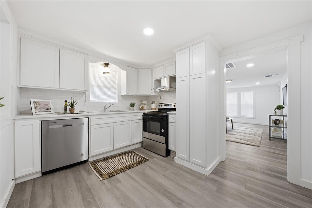 1116 Houston Street Waco, TX 76704 - Photo 7 of 16 Kitchen with stainless steel appliances, white cabinets, light countertops, light wood finished floors, and recessed lighting