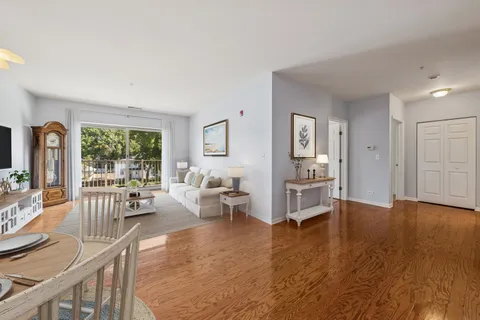 a living room with furniture wooden floor and a large window