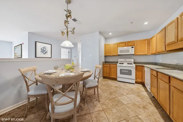 a kitchen with stainless steel appliances a table and chairs in it