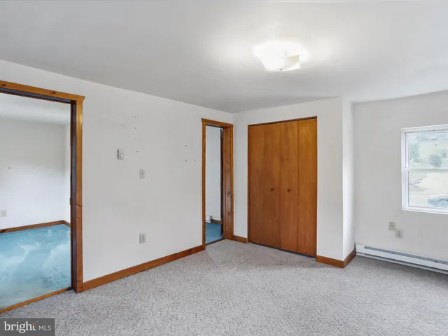 an empty room with windows and closet