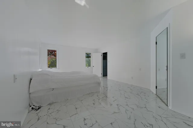 a view of a white house next to a yard with plants and trees