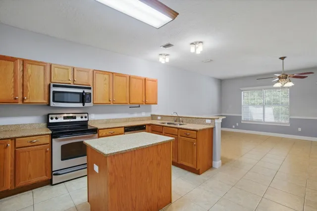 a kitchen with stainless steel appliances granite countertop a sink stove and microwave
