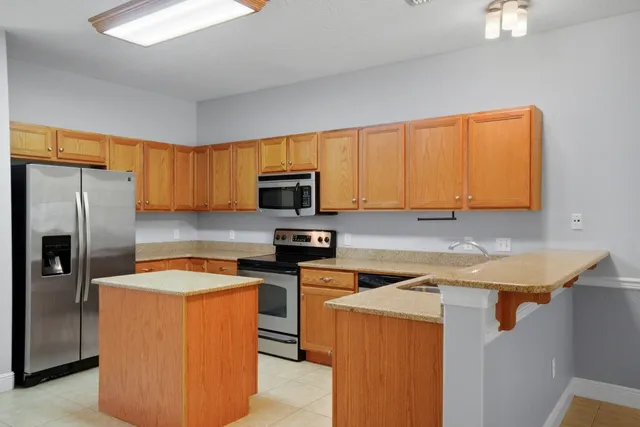 a kitchen with stainless steel appliances granite countertop a refrigerator stove a sink and dishwasher
