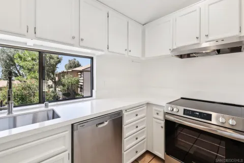 a kitchen with a stove and a white cabinets