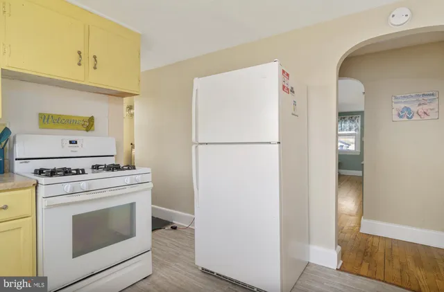 a kitchen with granite countertop white cabinets and white appliances