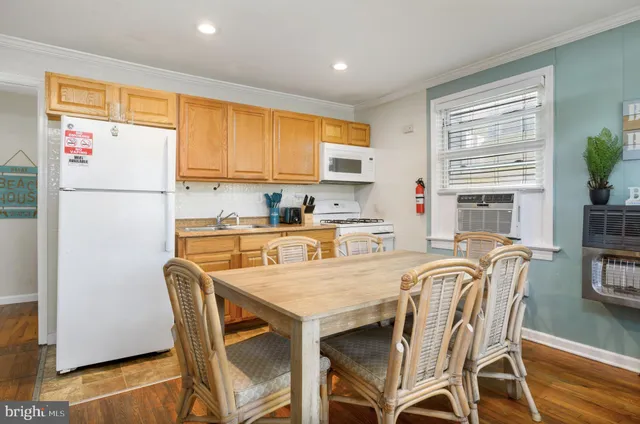 a kitchen with a table chairs refrigerator and cabinets