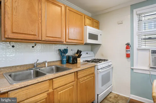 a kitchen with white cabinets and white appliances
