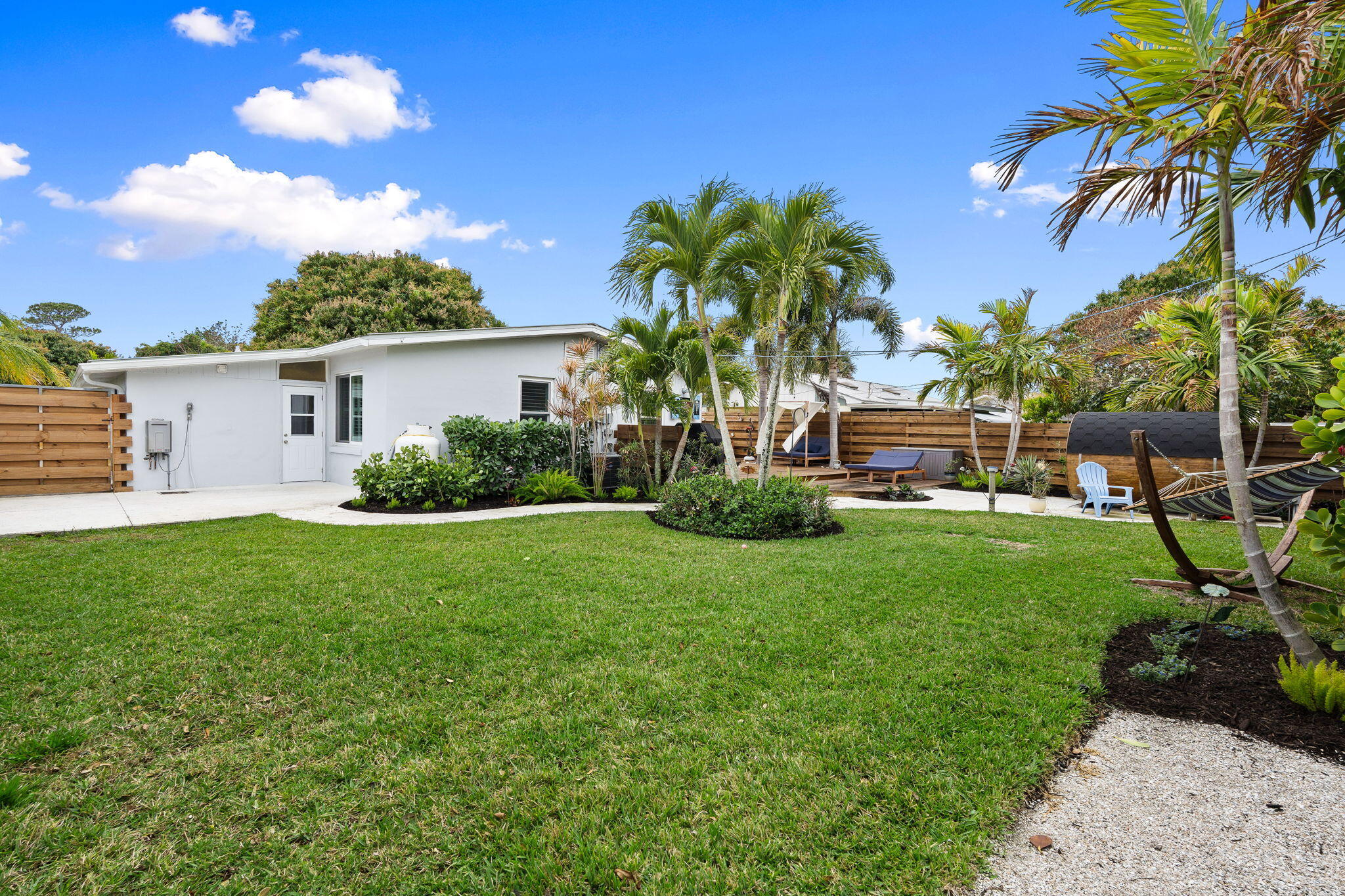 819 Southeast Stypmann Boulevard Stuart, FL 34994 - Photo 26 of 31 a view of a house with backyard sitting area and garden