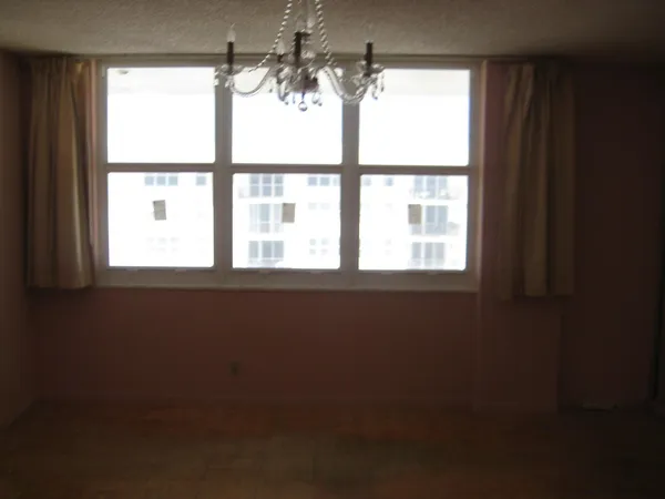 a view of a room with a chandelier fan and fire place