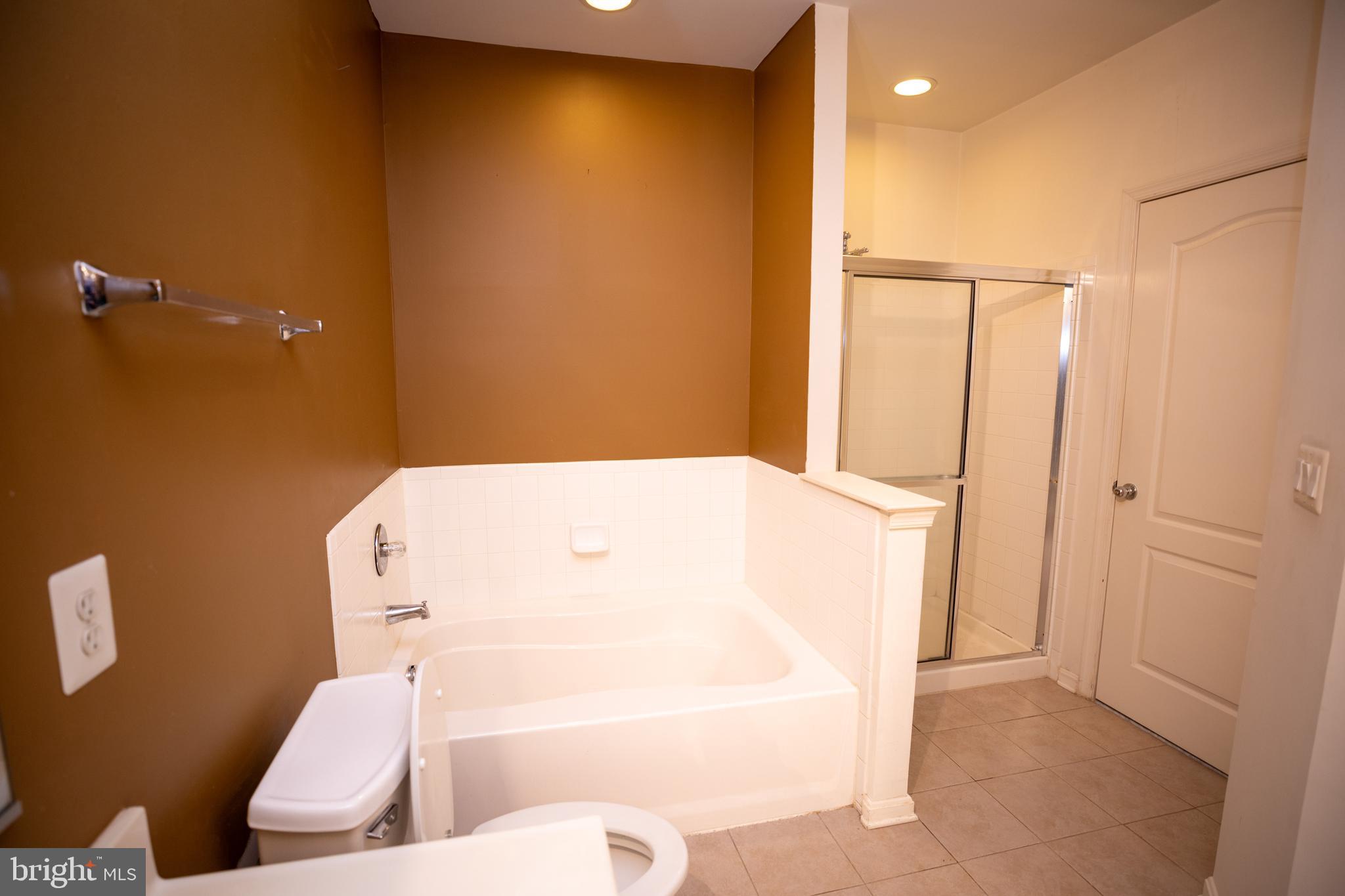 400 Symphony Circle, Unit 418H Cockeysville, MD 21030 - Photo 13 of 17 a bathroom with a bathtub and toilet