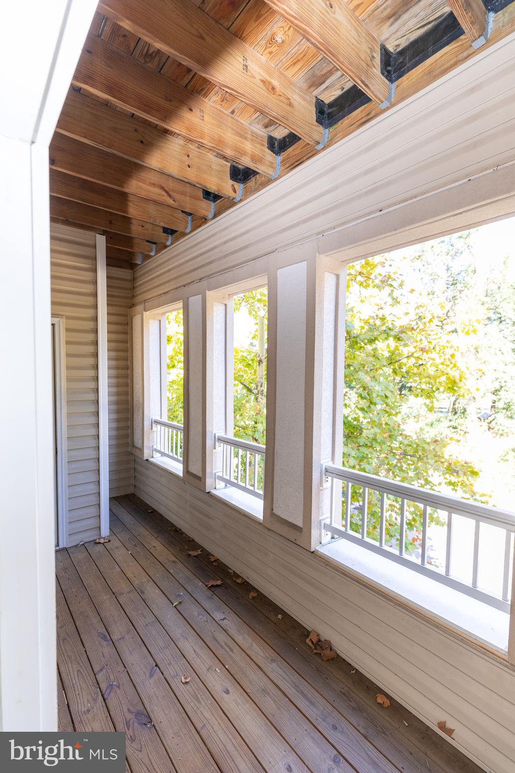 400 Symphony Circle, Unit 418H Cockeysville, MD 21030 - Photo 16 of 17 a view of an empty room with wooden floor and a window