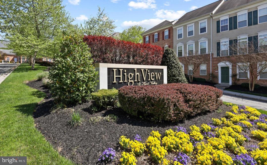 400 Symphony Circle, Unit 418H Cockeysville, MD 21030 - Photo 2 of 17 a sign that is sitting in front of a brick house with a large garden