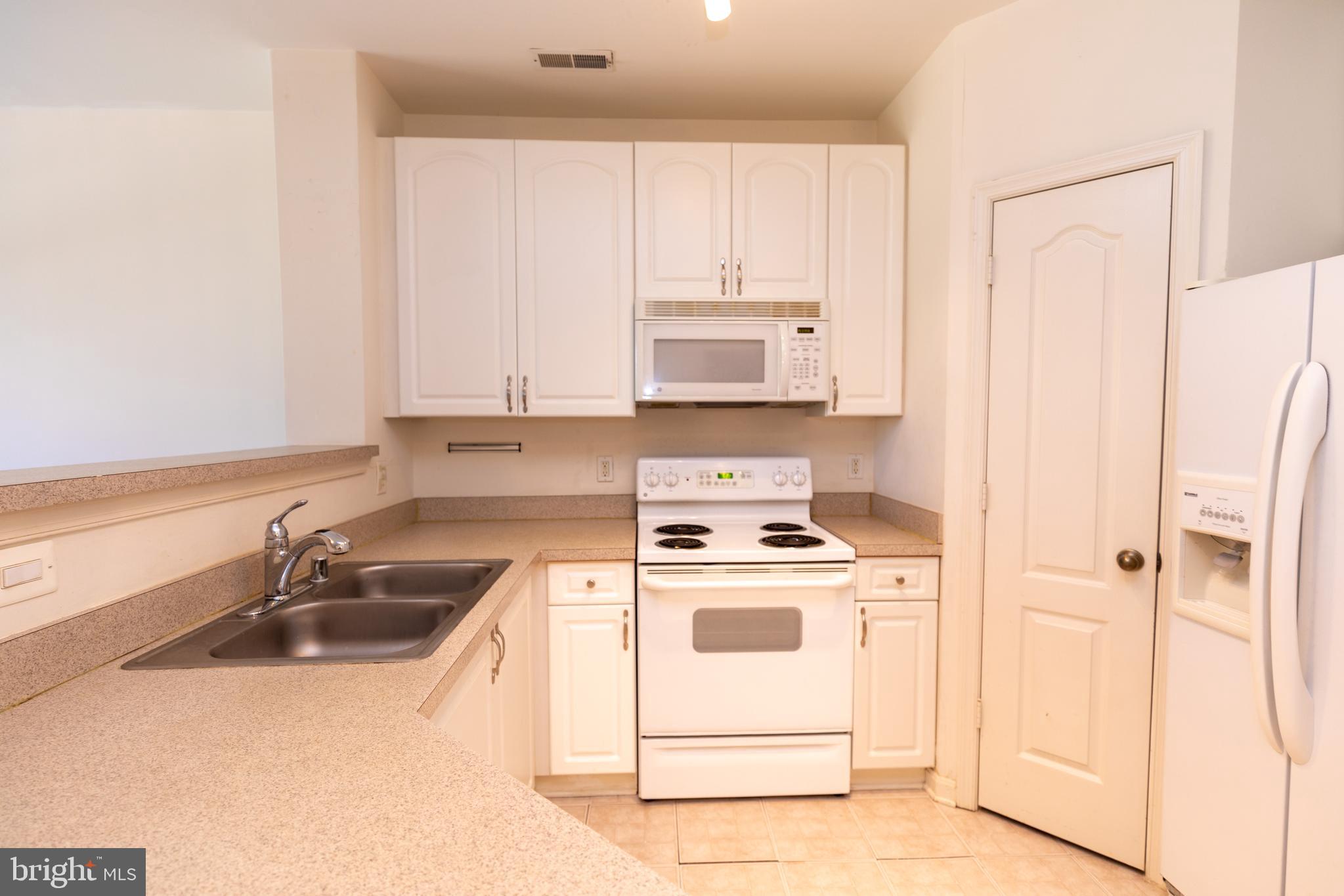 400 Symphony Circle, Unit 418H Cockeysville, MD 21030 - Photo 8 of 17 a kitchen with appliances a sink and cabinets