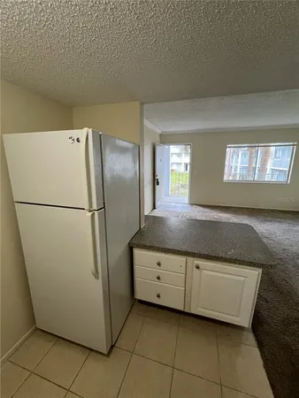 a kitchen with granite countertop a refrigerator and a sink