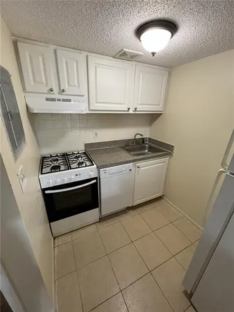 a kitchen with stainless steel appliances a stove a sink and cabinets