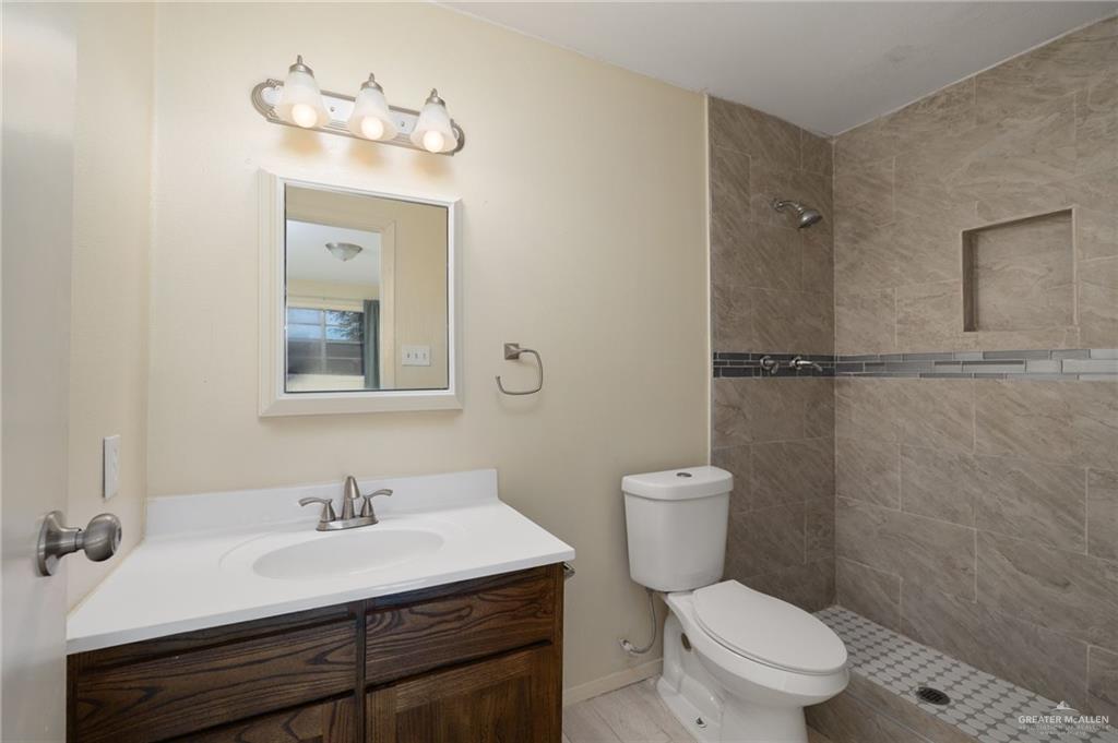 300 North 41st Street McAllen, TX 78501 - Photo 8 of 13 a bathroom with a toilet a sink and mirror
