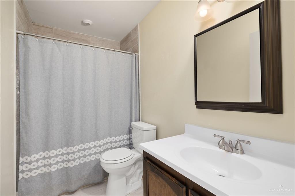 300 North 41st Street McAllen, TX 78501 - Photo 9 of 13 a bathroom with a sink a toilet and shower curtain