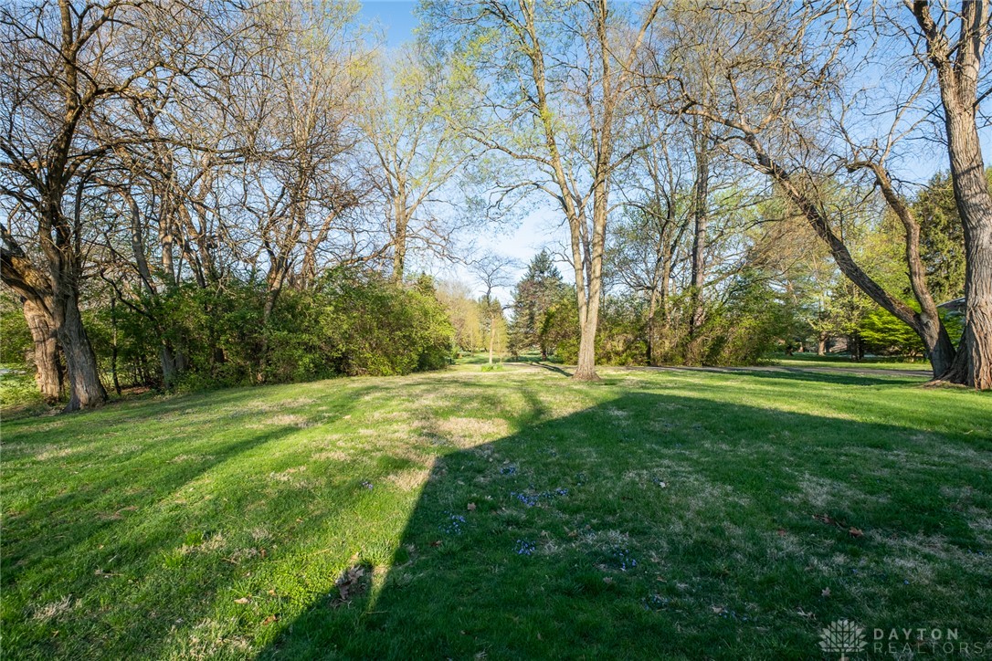 276 South Fairfield Road Bellbrook, OH 45305 - Photo 37 of 38 A verdant expanse of lawn bordered by mature trees creates a peaceful outdoor setting.