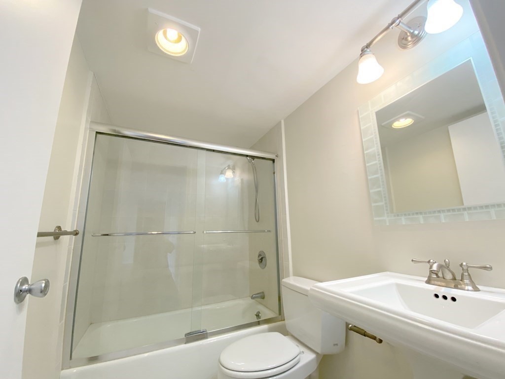 85 Brainerd Road, Unit 503 Boston, MA 02134 - Photo 11 of 21 a bathroom with a bathtub shower sink vanity and toilet