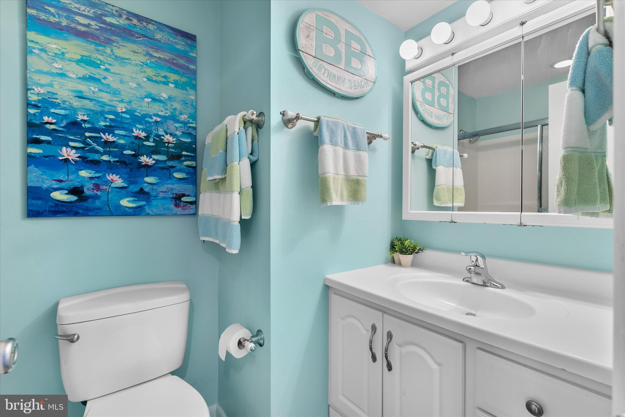 39362 Racquet Lane, Unit 8605 Bethany Beach, DE 19930 - Photo 18 of 53 a bathroom with a toilet sink and mirror