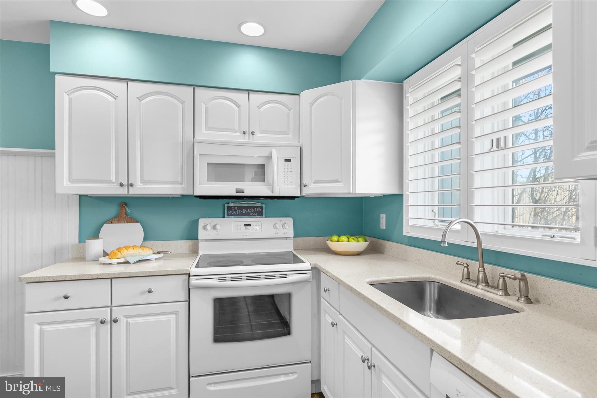 39362 Racquet Lane, Unit 8605 Bethany Beach, DE 19930 - Photo 9 of 53 a kitchen with white cabinets and white appliances