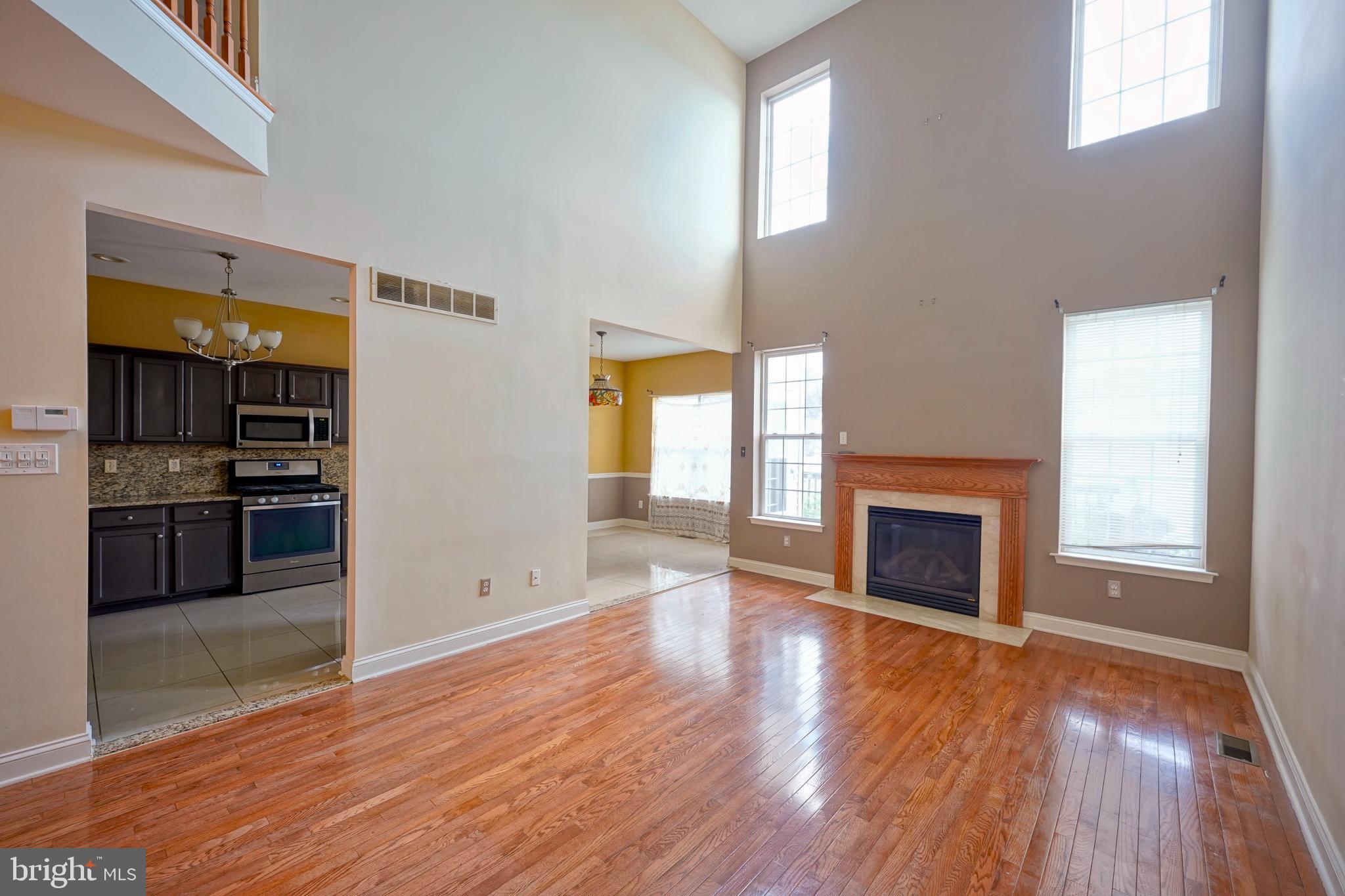 8 Bryce Road Berlin, NJ 08009 - Photo 11 of 36 an empty room with wooden floor fireplace and windows