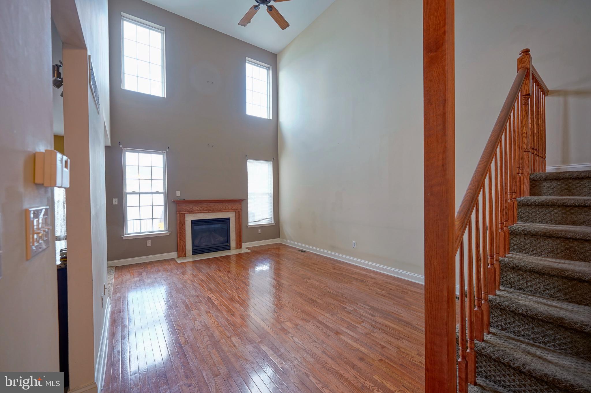 8 Bryce Road Berlin, NJ 08009 - Photo 10 of 36 a view of a livingroom with wooden floor fireplace and stairs