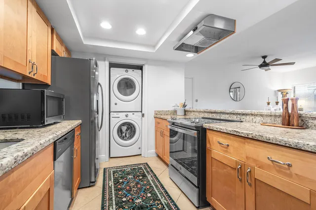 a kitchen with granite countertop a sink a stove and cabinets