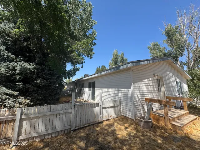 a view of a house with a small yard and wooden fence