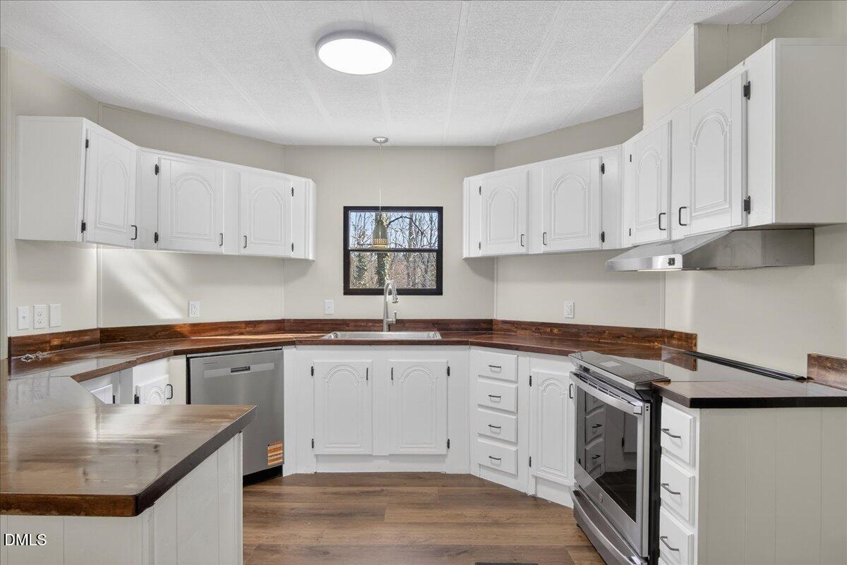 2428 Sims Bridge Road Kittrell, NC 27544 - Photo 11 of 57 a kitchen with granite countertop white cabinets and stainless steel appliances