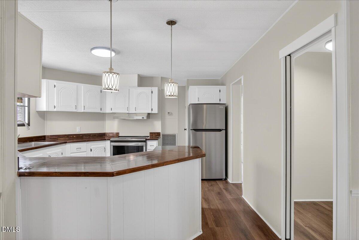 2428 Sims Bridge Road Kittrell, NC 27544 - Photo 12 of 57 a kitchen with stainless steel appliances granite countertop a refrigerator a sink a stove a microwave and wooden floors