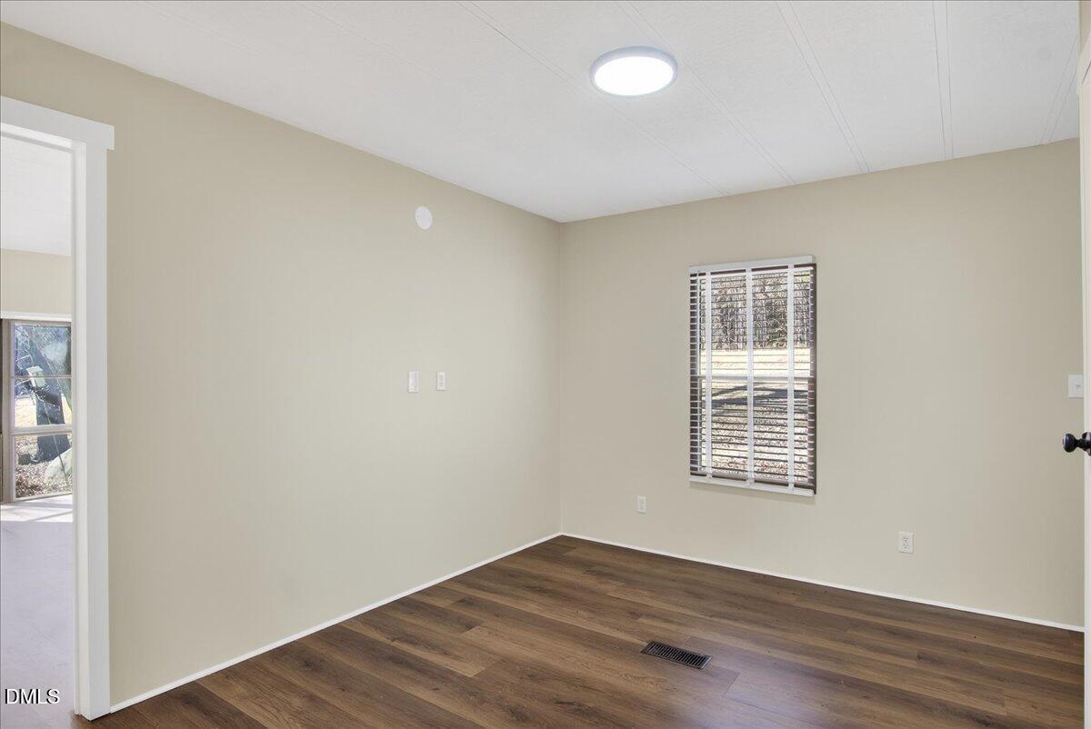 2428 Sims Bridge Road Kittrell, NC 27544 - Photo 18 of 57 an empty room with wooden floor and windows