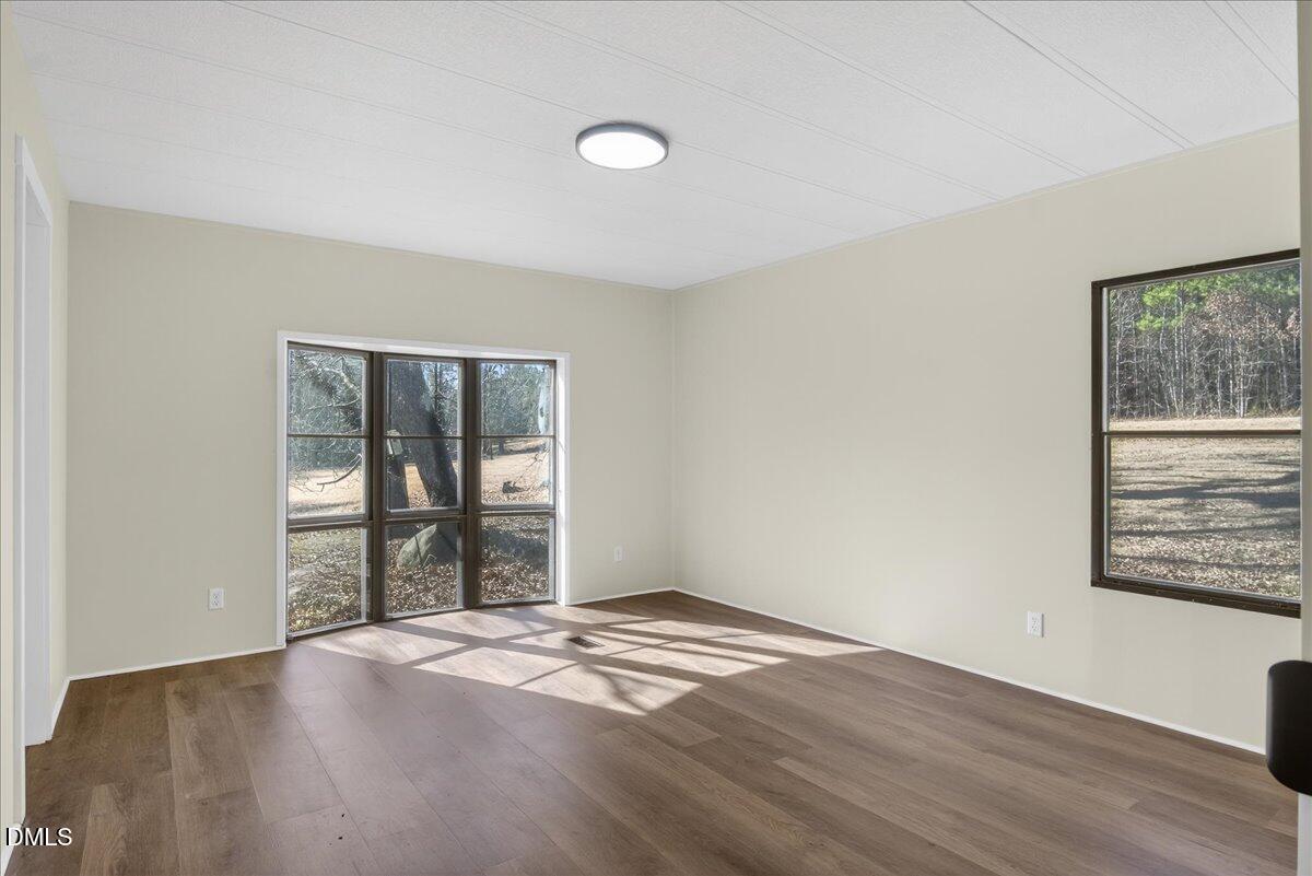 2428 Sims Bridge Road Kittrell, NC 27544 - Photo 21 of 57 a view of an empty room with wooden floor and a window