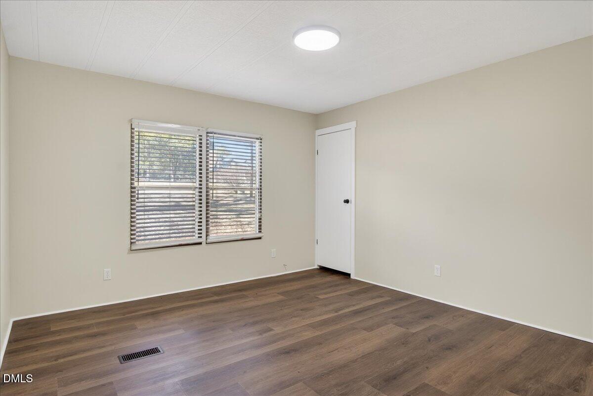 2428 Sims Bridge Road Kittrell, NC 27544 - Photo 27 of 57 an empty room with wooden floor and windows
