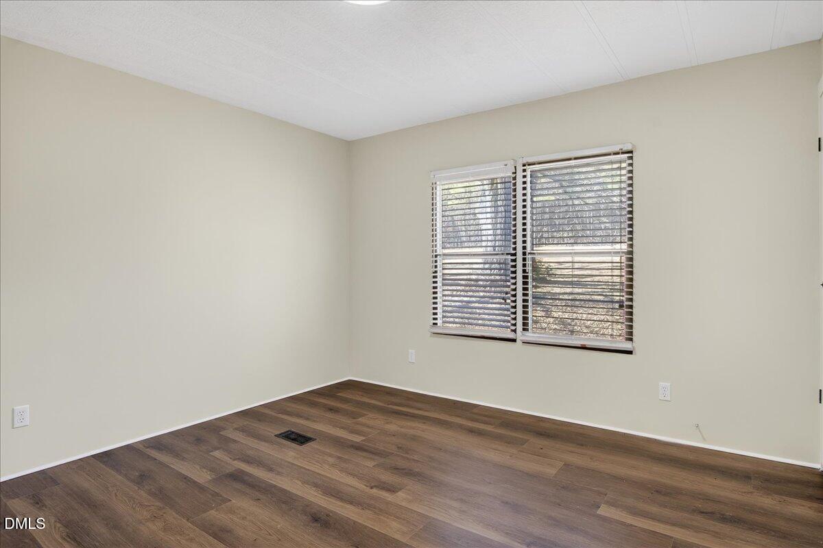 2428 Sims Bridge Road Kittrell, NC 27544 - Photo 29 of 57 a view of an empty room with wooden floor and a window