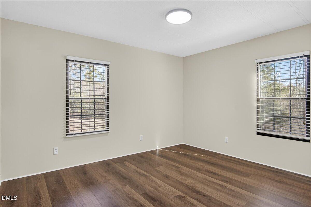 2428 Sims Bridge Road Kittrell, NC 27544 - Photo 31 of 57 an empty room with wooden floor and windows