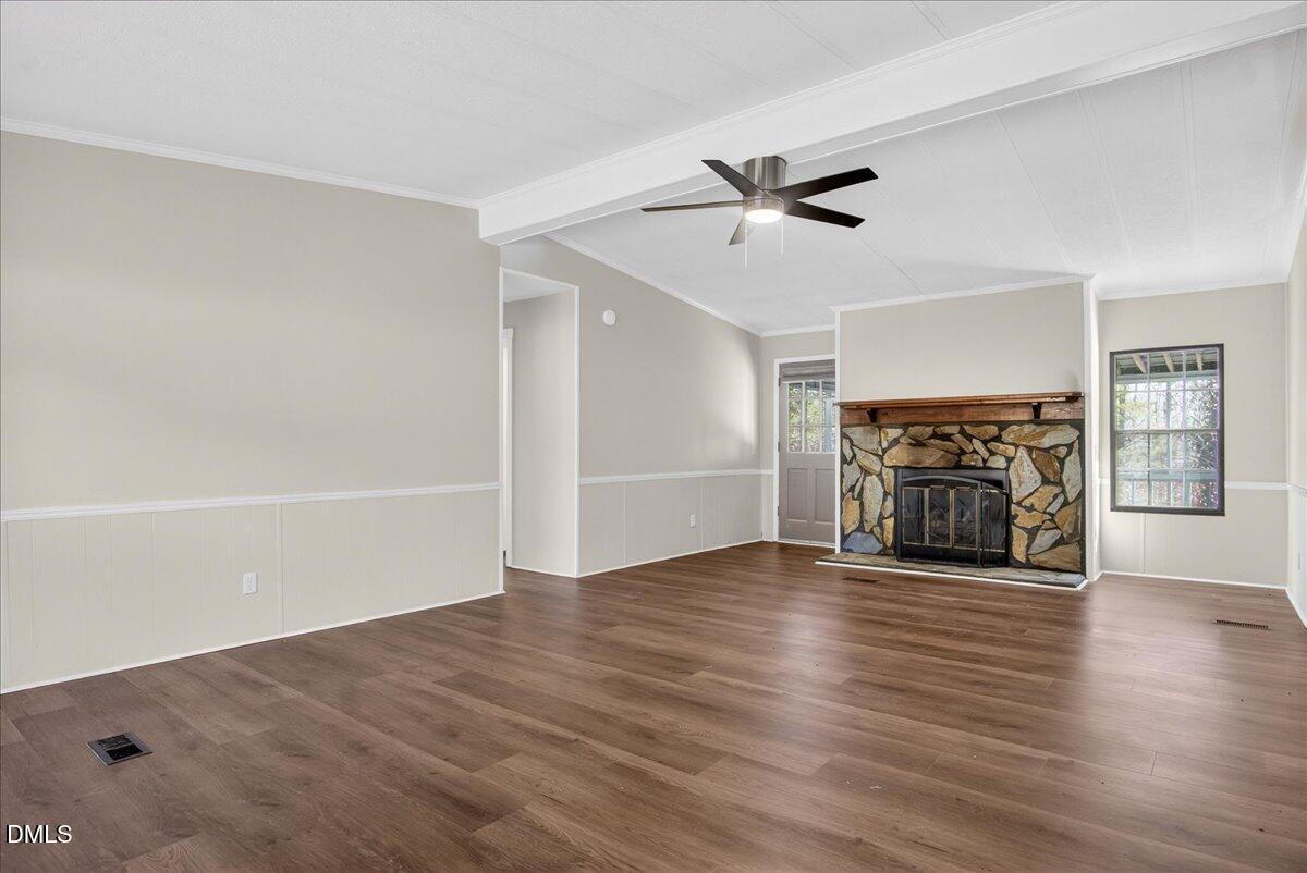 2428 Sims Bridge Road Kittrell, NC 27544 - Photo 8 of 57 a view of an empty room with wooden floor fireplace and a window